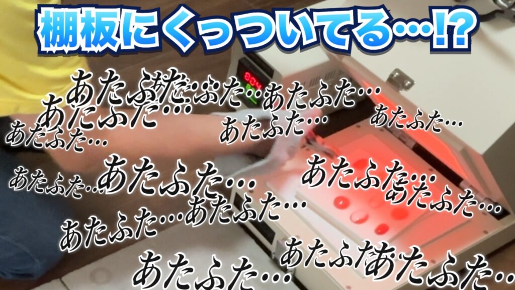 棚板にガラスがくっついてあたふたしている失敗シーン(動画より)